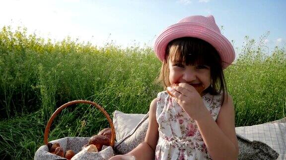 野餐自然可爱的小女孩肖像吃百吉饼生面团产品喝牛奶在日落孩子在家庭野餐