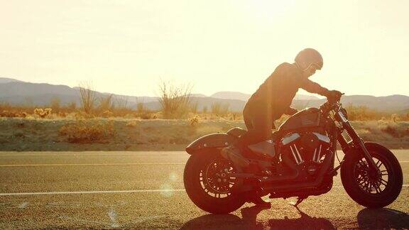 日落时分骑上黑色摩托车的男人