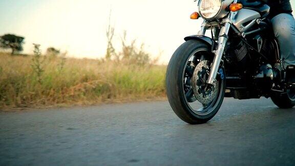 日落时分摩托车手在空旷的路上骑着摩托车