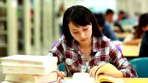 漂亮的大学生在图书馆学习
