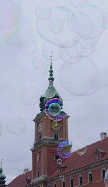 垂直视频-慢动作肥皂泡飞在华沙皇家城堡的背景华沙老城的宫殿广场