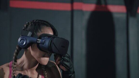 年轻的亚洲女性戴着VR头盔训练她的拳击动作