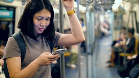 女性在地铁上使用智能手机
