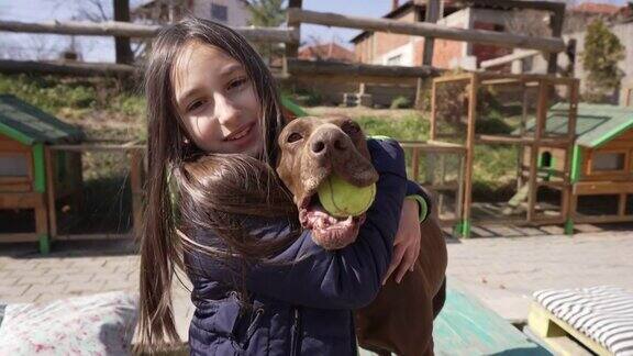可爱的小女孩在动物救助中心拥抱小狗