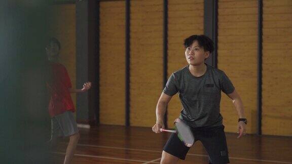 亚洲华人羽毛球运动员在羽毛球场上进行比赛