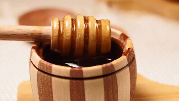 从一罐蜂蜜中收集蜂蜜的桶罐蜂蜜特写镜头