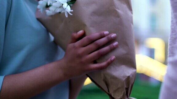 男子送给年轻女子一束美丽的甘菊令人愉快的鲜花礼物