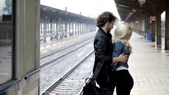 年轻夫妇拥抱并说再见前男朋友上火车离开