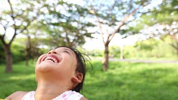 亚洲女孩笑着父亲抱着女儿在公园里