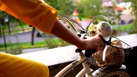 近景的城市自行车的车把与铃篮子和鲜花清晨一个面目全非的女人骑着一辆城市自行车替身Slowmotion