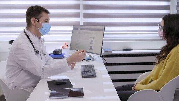 全科医生戴上防护口罩并与女病人进行咨询