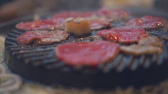 烹饪烧烤在炉子上的木炭上烤关闭牛肉烤在日本餐厅用于烧烤或日式食物的生牛肉片