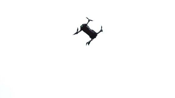 低角度拍摄无人机四旋翼与数码相机在蓝天与云无人机在云层背景的天空中高速飞行