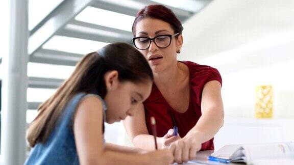 母亲帮助女儿在家做家庭作业的教育
