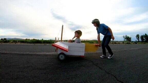 两个小男孩驾驶老式玩具飞机