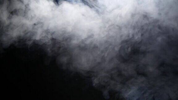 雾蒸汽烟雾云的缓慢运动在黑色的背景