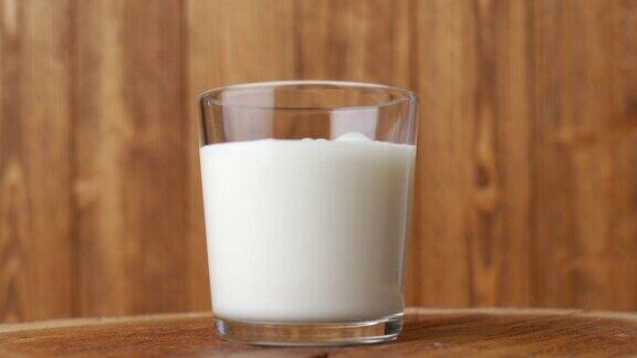 将白酸奶或冰沙倒入玻璃杯中放在木桌上