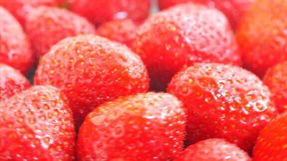 新鲜、成熟、多汁的草莓轮作红草莓顺时针旋转诱人的浆果滴在托盘上旋转