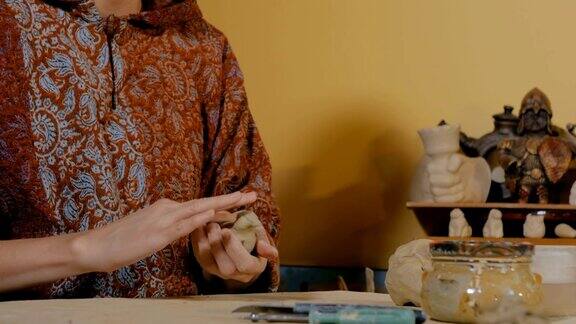 陶艺作坊里的女陶工正在制作陶瓷纪念品便士哨子