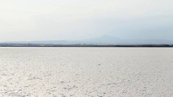 塞浦路斯拉纳卡干盐湖全景图日落时白色的外壳在阳光的映衬下结出晶体