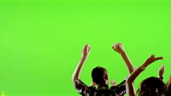 一群粉丝在绿色屏幕上跳舞音乐会跳跳舞缓慢的运动用红色史诗电影摄像机拍摄