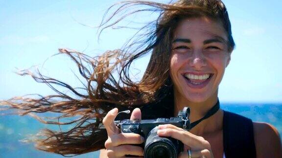 一个女孩和她的男朋友在海边度假拍了一些照片对着相机微笑热爱摄影和摄影课程热爱旅游和旅游景点