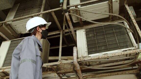 亚洲女技术员检查大楼内空调泄漏女性工程师联系