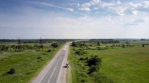 空中拖拉机沿着道路行驶在路边割草