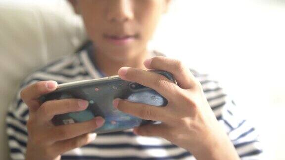 快乐的亚洲女孩在家里用智能手机玩网络游戏或看电影生活理念