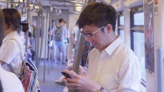一个在地铁里用手机的男人
