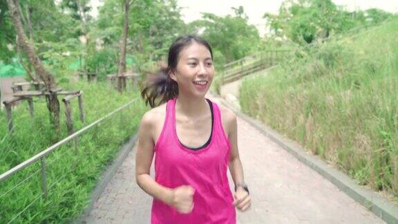 慢动作-健康美丽的年轻亚洲女跑步者在运动服装在城市公园的街道上跑步和慢跑生活方式健康和积极的女性锻炼在城市