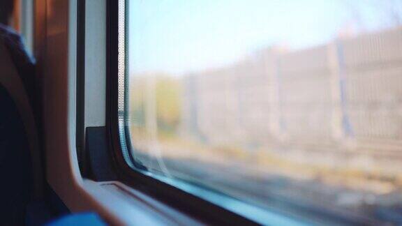 从驾驶高速列车的内部视图模糊的铁路和外部视图本地列车和乘客在火车站行驶从乘坐火车的窗口看铁路运输