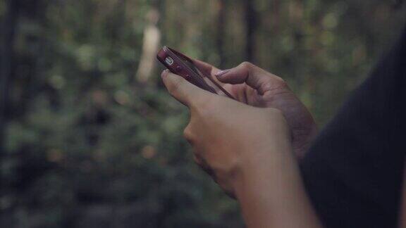 一个女孩在森林里用智能手机搜索网站