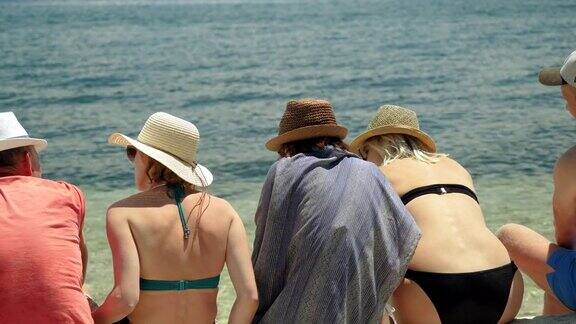 五个朋友坐在地中海附近的沙滩上希腊4k
