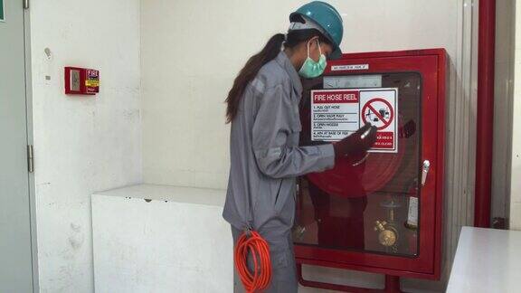 亚洲女技术员检查消防水龙带轮修理内螺纹检查报警状态