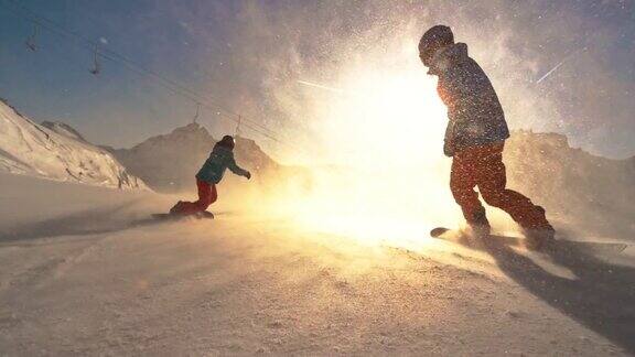 SLOMOTS两名滑雪者朝着太阳沿着斜坡滑行
