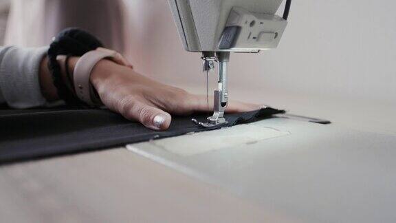 特写镜头:在服装厂女工用缝纫机缝制织物
