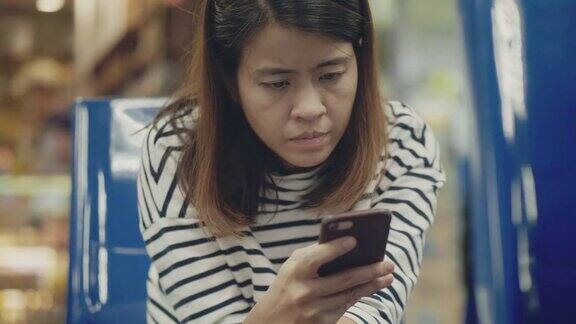 一名亚洲女性在机场使用智能手机