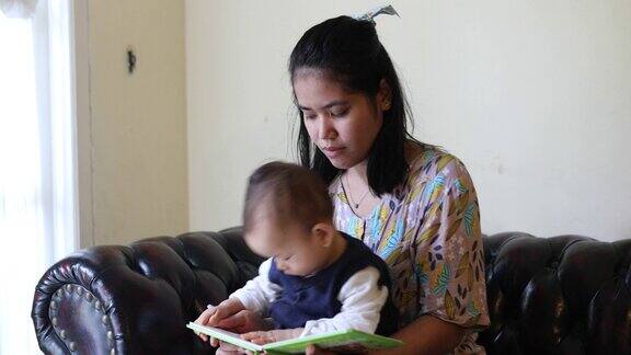 一位年轻的母亲给她的小男孩读书