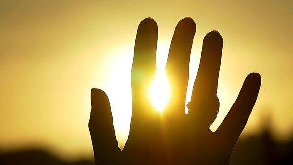 手在太阳的剪影举起