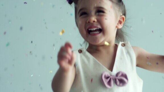 可爱的小女孩(2-3岁)喜欢玩五彩纸屑