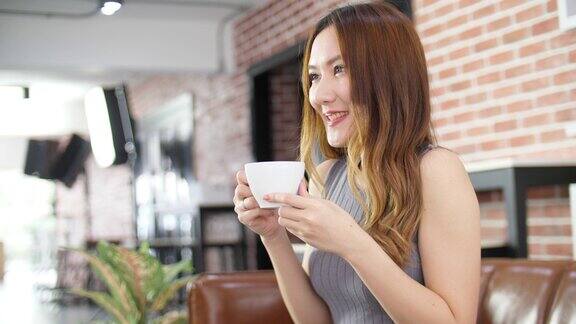 女人喝咖啡享受Tatse年轻的女人放松在咖啡馆