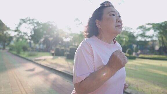 亚洲老年妇女在公园内跑步阳光明媚的日子慢动作退休健康生活方式活动老年人健康保健保险计划夏季炎热的天气老年人健康保健