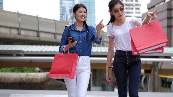 购物:朋友们拿着购物袋在城市里散步