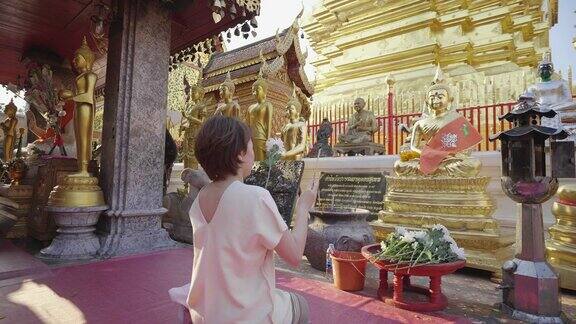 在寺庙里与佛陀一起祈祷的亚洲妇女