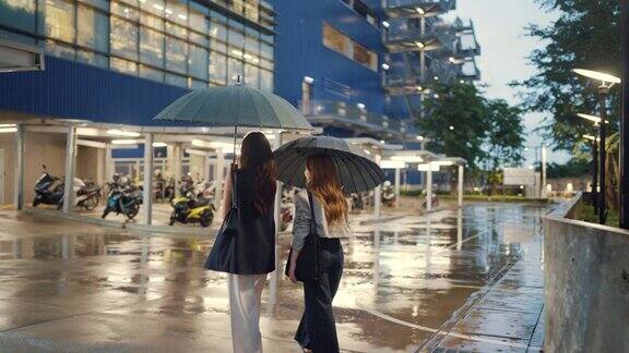 两个亚洲妇女冒着大雨在回家的路上