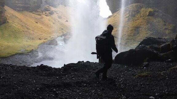 走在Seljalandsfoss瀑布后面的人