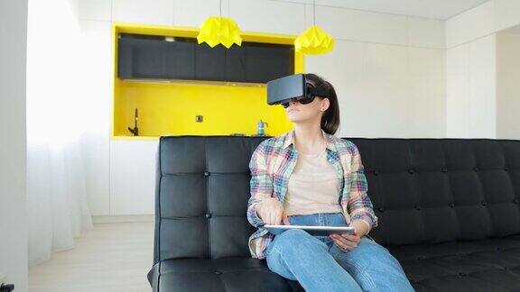 女人在家里的沙发上使用虚拟现实耳机