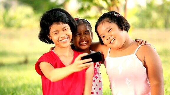 一群微笑的女孩用智能手机自拍