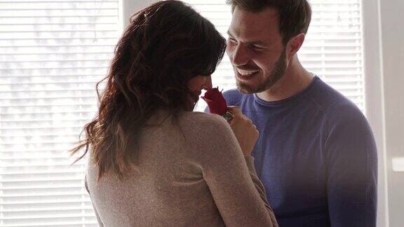 丈夫送一枝红玫瑰给爱妻共同分享爱的时刻